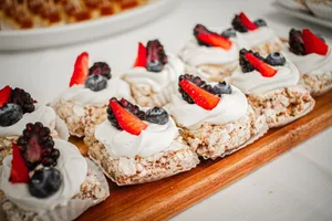 Close-up of berry-topped desserts with whipped cream on a wooden tray, perfect for a sweet indulgence. jigsaw puzzle