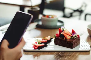 Artfully arranged chocolate dessert garnished with fresh strawberries and edible flowers, captured indoors. jigsaw puzzle