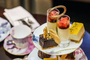Indulge in a selection of gourmet desserts at an elegant high tea setup in London. jigsaw puzzle