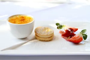 A beautifully plated dessert trio featuring creme brulee, a cookie, and fresh strawberries. jigsaw puzzle