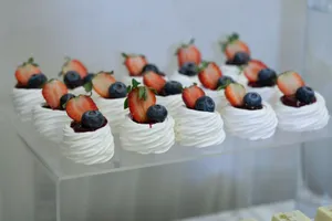 Delicious meringue desserts topped with fresh strawberries and blueberries, perfect for events and parties. jigsaw puzzle