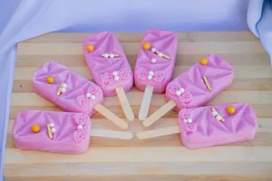 Vibrant and decorative pink popsicles arranged on a wooden board, perfect for summer treats. jigsaw puzzle