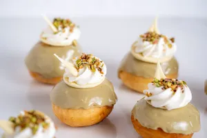 Delicious donuts topped with pistachio glaze and whipped cream, perfect for dessert lovers. jigsaw puzzle