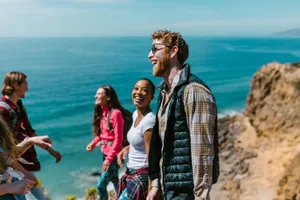 A joyful group of friends hiking along a scenic coastline, enjoying laughter and good company. jigsaw puzzle