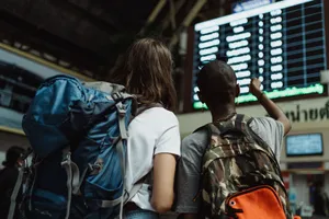 Two backpackers checking the digital board at a train station for travel information. jigsaw puzzle