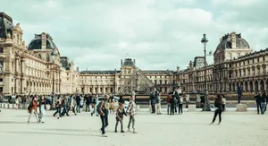 A bustling scene of people walking in front of the iconic Louvre Museum, Paris. jigsaw puzzle