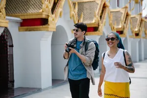 Two tourists with backpacks and cameras enjoy a sunny day exploring ornate Thai architecture. jigsaw puzzle