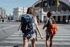 Two travelers with backpacks cross a city street near a historic building, symbolizing adventure and travel. jigsaw puzzle