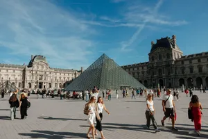 Crowds gather around the iconic glass Pyramid of the Louvre Museum in Paris, France on a sunny day. jigsaw puzzle