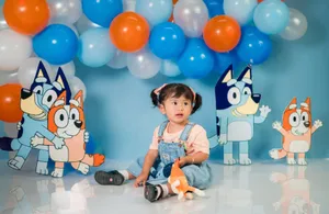 Child in cute setting with balloons and animated character cutouts in a colorful birthday setup. jigsaw puzzle