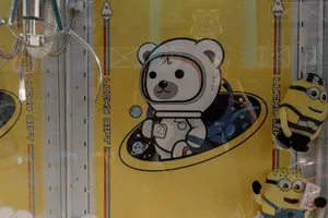 Claw machine with plush toys at an arcade, featuring vibrant yellow design and graphic elements. jigsaw puzzle