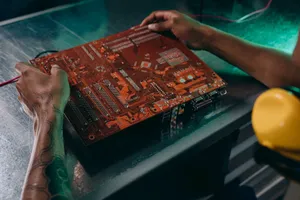 Close-up of a technician working on a circuit board in an industrial setting. jigsaw puzzle