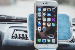Close-up of a smartphone mounted on a car dashboard showing home screen with apps. jigsaw puzzle