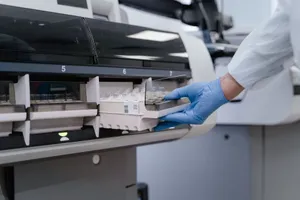 A lab technician in blue gloves handling samples in a scientific instrument. jigsaw puzzle