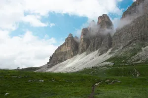 Breathtaking view of Tre Cime di Lavaredo with mist and vibrant greenery in the Dolomites, Italy. jigsaw puzzle
