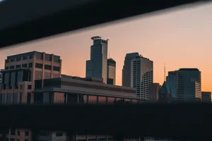 Captivating view of Minneapolis skyline during sunset, showcasing modern architecture in a serene twilight. jigsaw puzzle