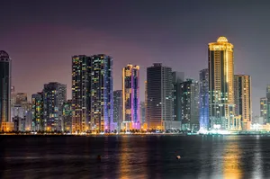A captivating view of Sharjah's illuminated skyline reflecting on the waterfront at night. jigsaw puzzle