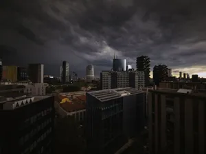 A dark, stormy sky looms over a modern urban skyline at dusk, creating a dramatic cityscape. jigsaw puzzle