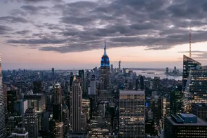 Contemporary skyscraper facades against sea under sky with clouds on Manhattan island at sunset jigsaw puzzle