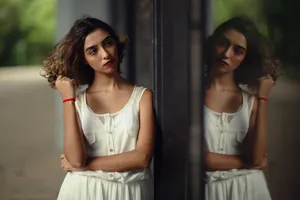Elegant young woman leaning on a mirror outdoors, captured in São Paulo. jigsaw puzzle