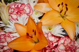 A vivid floral arrangement featuring orange lilies and pink carnations in full bloom. jigsaw puzzle