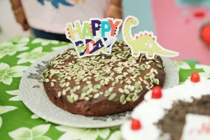 A fun dinosaur-themed birthday cake with colorful decorations and seeds. jigsaw puzzle