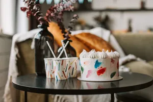 Vibrant cake with decorated cups on a table indoors, creating a cozy and artistic ambiance. jigsaw puzzle
