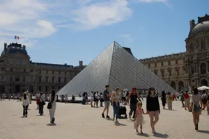 Visitors enjoy a sunny day at the iconic Louvre Pyramid in Paris, France. jigsaw puzzle