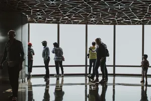 Silhouettes of tourists observing the Dubai skyline from an indoor observation deck. jigsaw puzzle