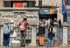 Visitors engage with an ancient stone monument in Istanbul on a sunny day. jigsaw puzzle
