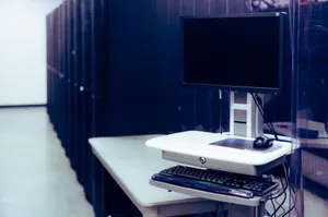 Contemporary computer with black screen placed on stand near row of server steel racks in data center jigsaw puzzle