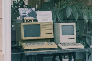 Retro Apple computers with keyboards displayed in a Tokyo store window, showcasing early tech design. jigsaw puzzle