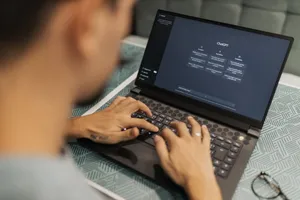 A focused individual types on a laptop running AI software indoors. jigsaw puzzle