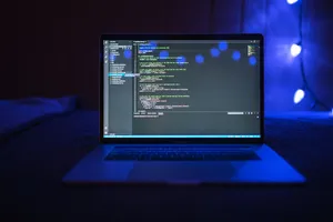 Close-up of a laptop screen displaying code, set against a dark backdrop with blue lighting for a tech-focused ambiance. jigsaw puzzle