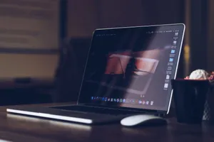 A sleek laptop on a wooden desk with a cup, creating a warm and cozy workspace atmosphere. jigsaw puzzle