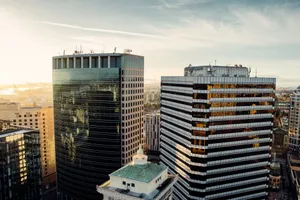 Aerial view of modern office buildings with sunrise reflections in a vibrant urban skyline. jigsaw puzzle
