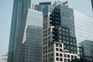 A striking view of modern glass skyscrapers reflecting the urban cityscape under a clear sky. jigsaw puzzle