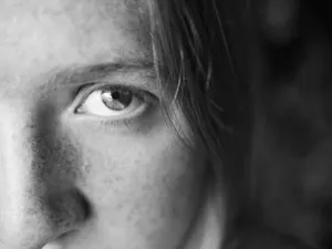 Black-and-white close-up of a woman's eye and part of her face with freckles, creating an intimate portrait. jigsaw puzzle