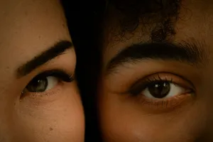 A detailed close-up showing the expressive eyes of two diverse women in natural light. jigsaw puzzle
