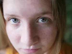 Detailed close-up portrait focusing on a young caucasian woman's eyes and freckles. jigsaw puzzle