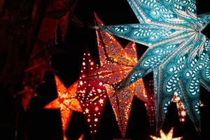 Colorful illuminated star-shaped lanterns glowing brightly against a dark night sky. jigsaw puzzle