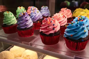 Delightful array of colorful cupcakes with vibrant icing and sprinkles in a bakery display. jigsaw puzzle