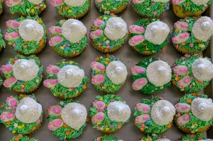 A tray of colorful Easter bunny-themed cupcakes with vibrant icing decorations and sprinkles. jigsaw puzzle