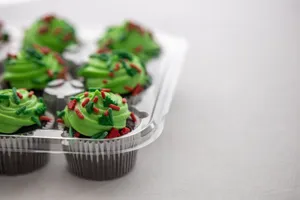 A tray of festive green frosted cupcakes with red sprinkles, perfect for holiday celebrations. jigsaw puzzle