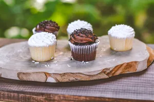 A tempting display of chocolate and vanilla cupcakes on a wooden board, perfect for dessert lovers. jigsaw puzzle