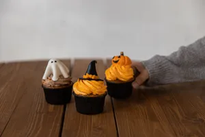 Halloween-themed cupcakes decorated with ghost, witch hat, and pumpkin, perfect for festive desserts. jigsaw puzzle