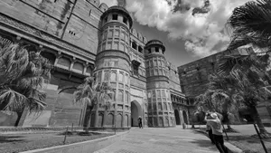 Black and white photo of the iconic Agra Fort exterior with tourists and palm trees. jigsaw puzzle