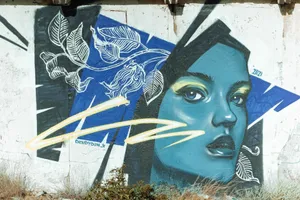 Colorful graffiti mural depicting a woman's face with floral elements on an urban wall. jigsaw puzzle