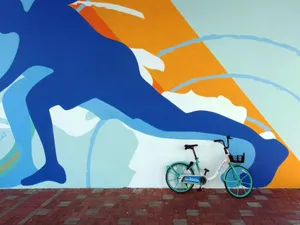 Vibrant abstract mural featuring a bicycle parked against it on a city street. jigsaw puzzle