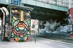 Dynamic street art depicting colorful and monochrome murals under a bridge in a cityscape. Captures urban creativity. jigsaw puzzle